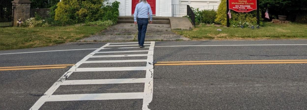 A man crossing the road at a marked crosswalk