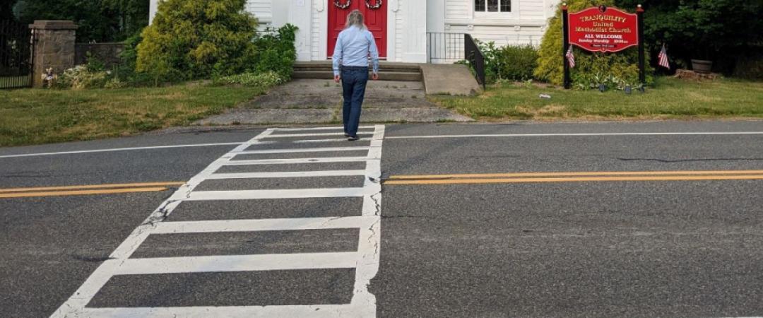 A man crossing the road at a marked crosswalk